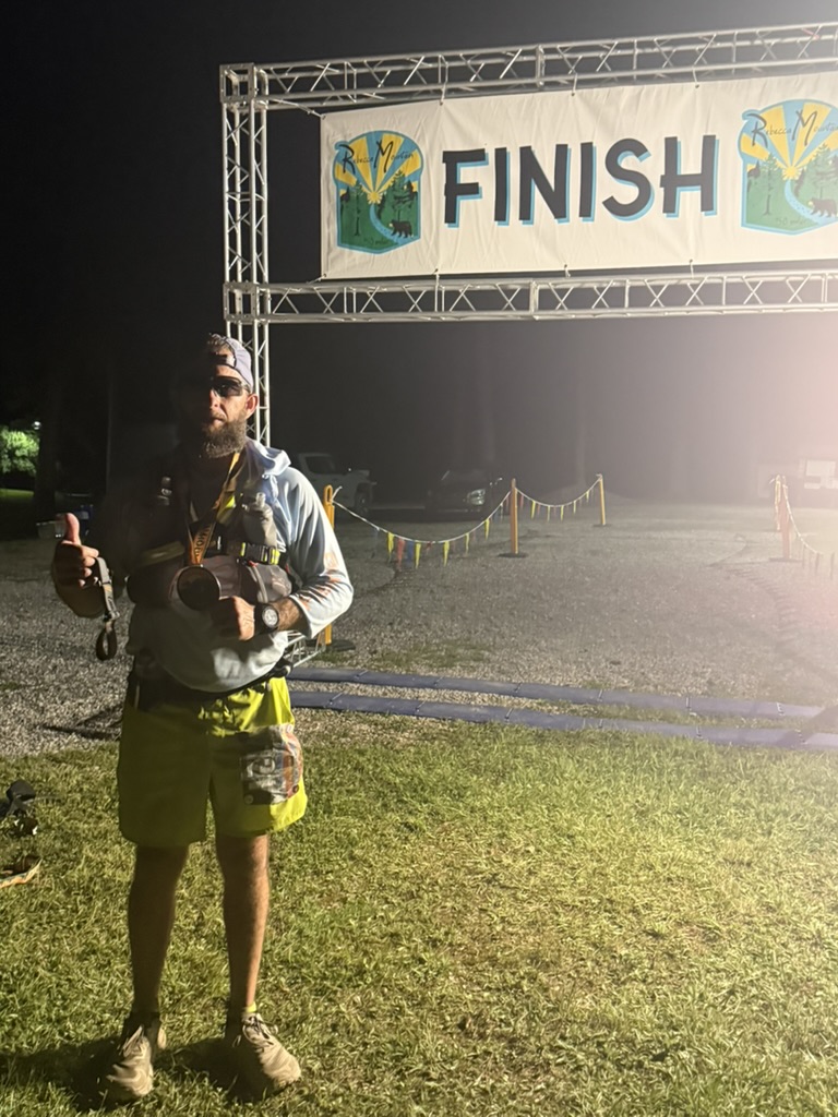 Nick under the finish line arch after 50 miles